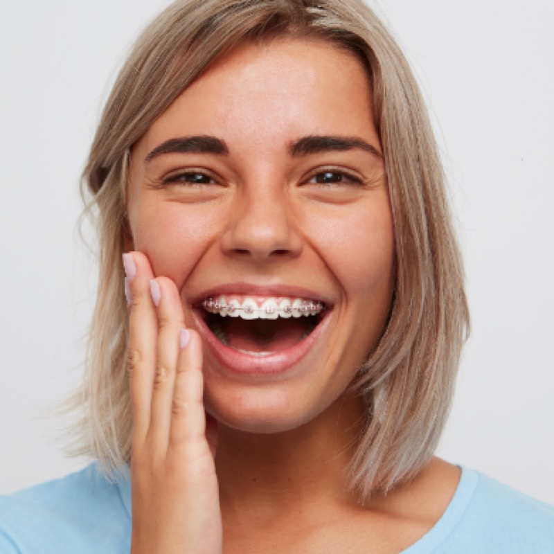Young woman laughing, wearing fixed braces