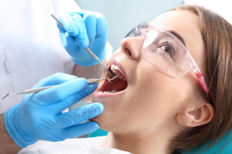 Patient wearing protective glasses during professional teeth cleaning