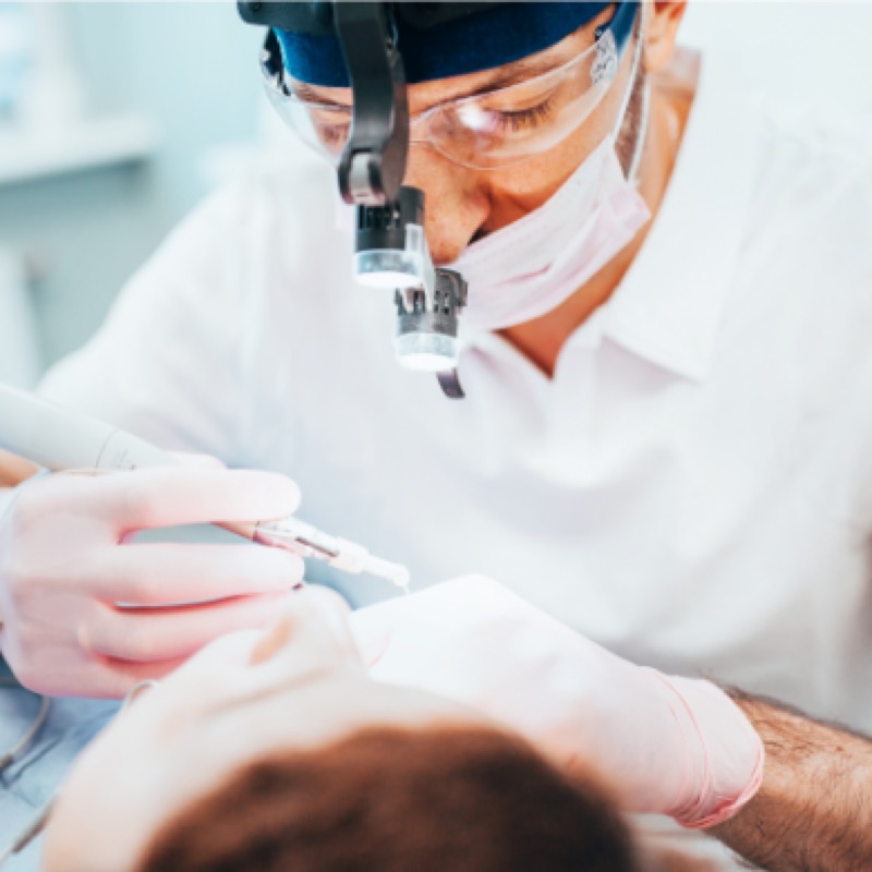Dentist wearing magnifying loupes and a light during precise treatment