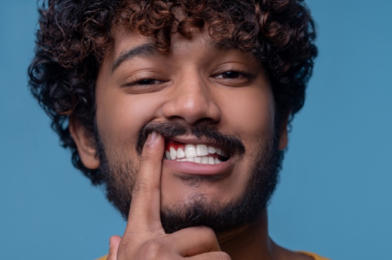 Man pointing to his red, inflamed gums